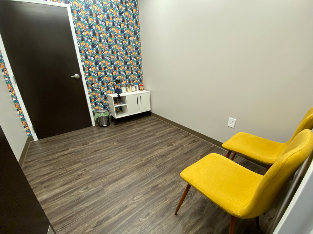 an exam room with nice chairs and fun dog wallpaper