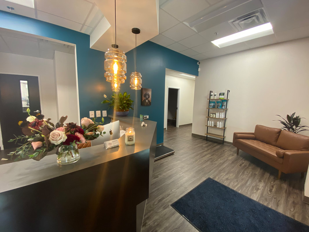 A warm and inviting lobby with a leather couch and bright teal wall